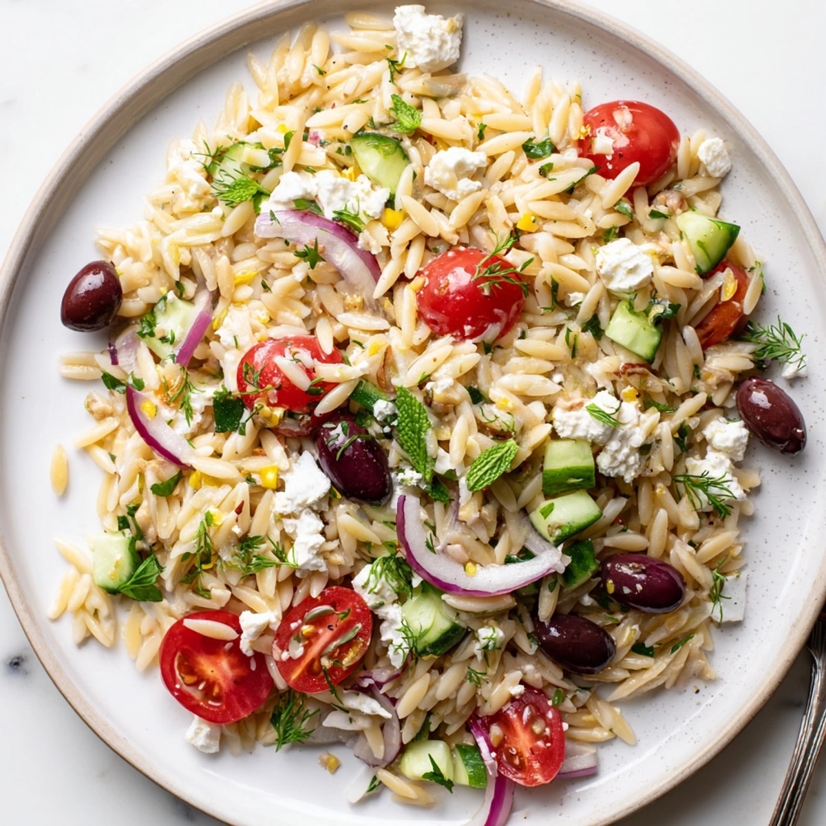 Creamy Greek Orzo with Feta and Olives, a vibrant pasta salad ready to serve.