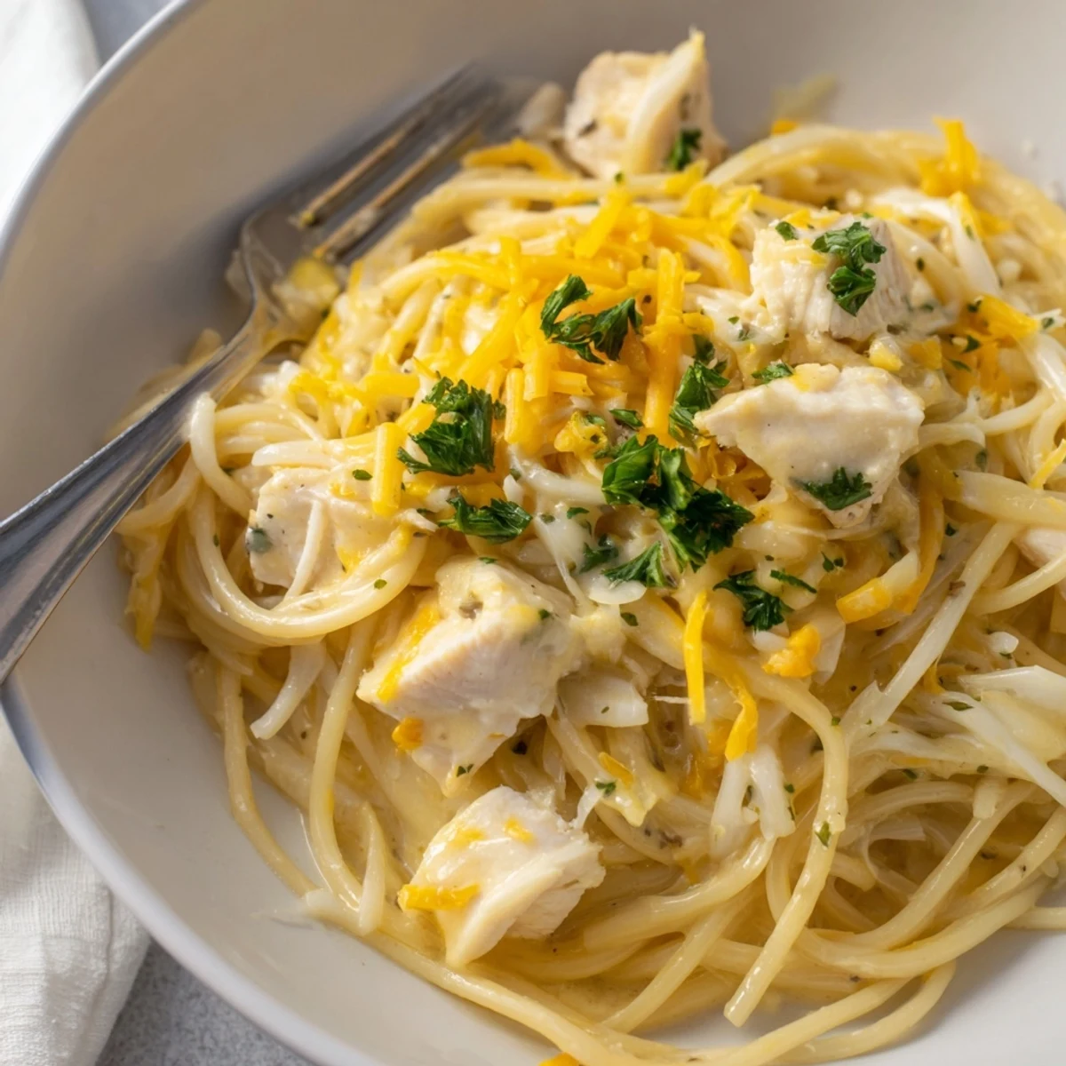 Comforting Monterey Chicken Spaghetti topped with cheese, combining savory chicken and pasta.  