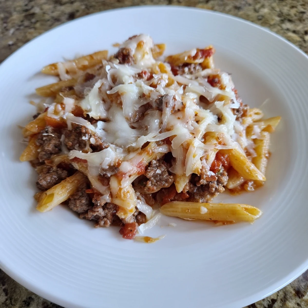 A bubbly casserole of Cheesy Beef & Penne Bake with melted mozzarella and Parmesan cheese for a delicious meal.