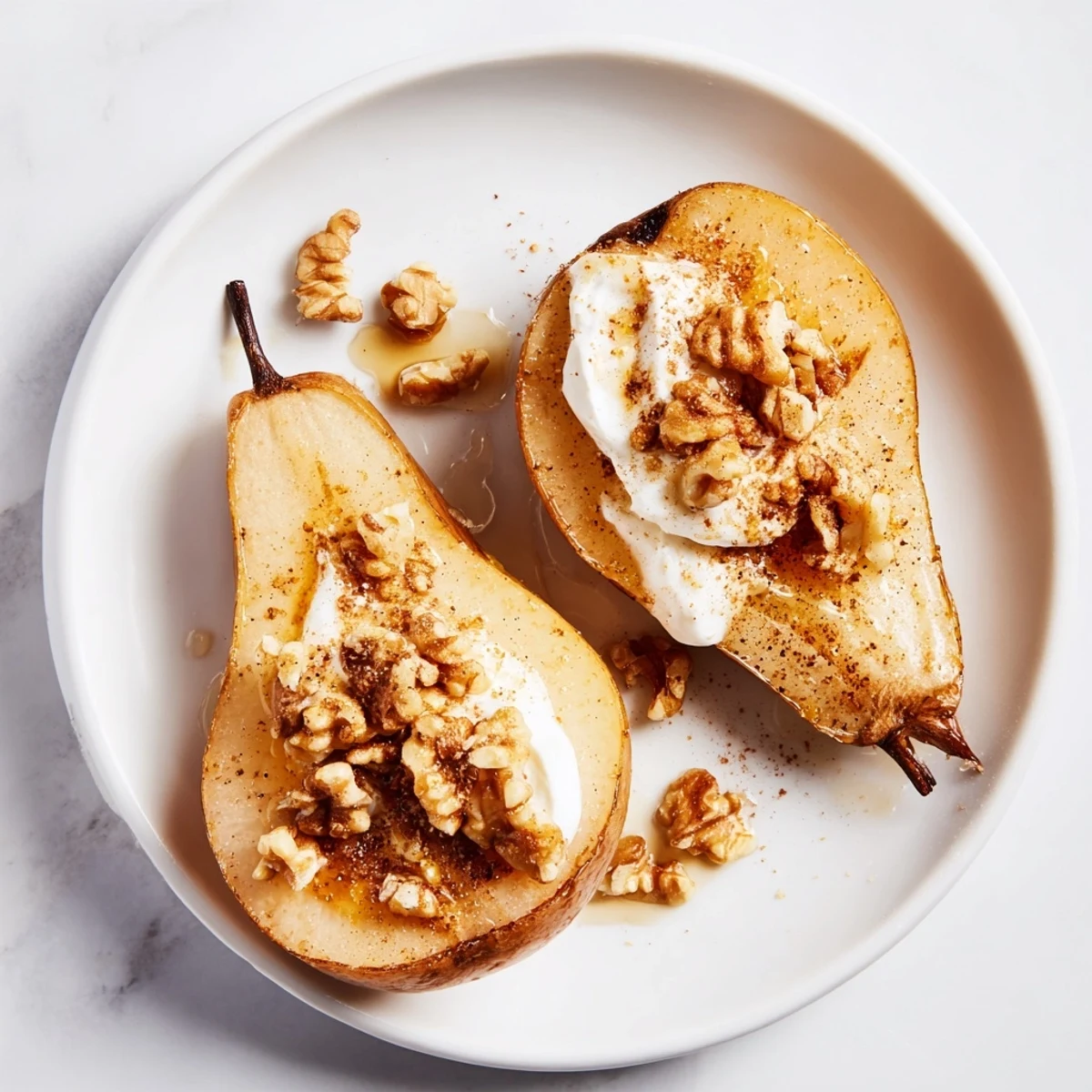 Warm, tender roasted pears with cinnamon, walnuts, and Greek yogurt—a sweet dessert.