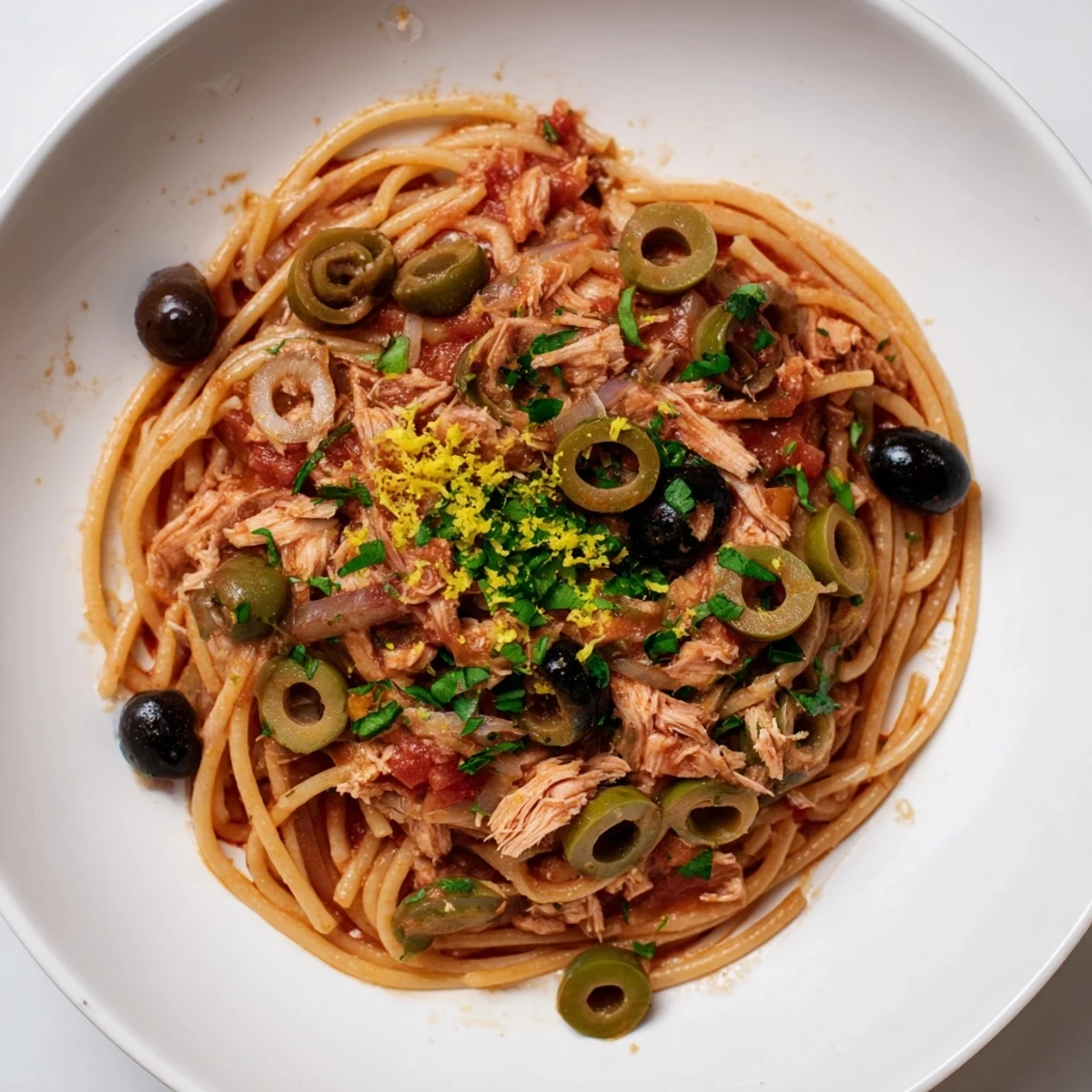 A warm bowl of Pasta with Tuna, Olives & Capers, ready to enjoy with a burst of fresh lemon zest.