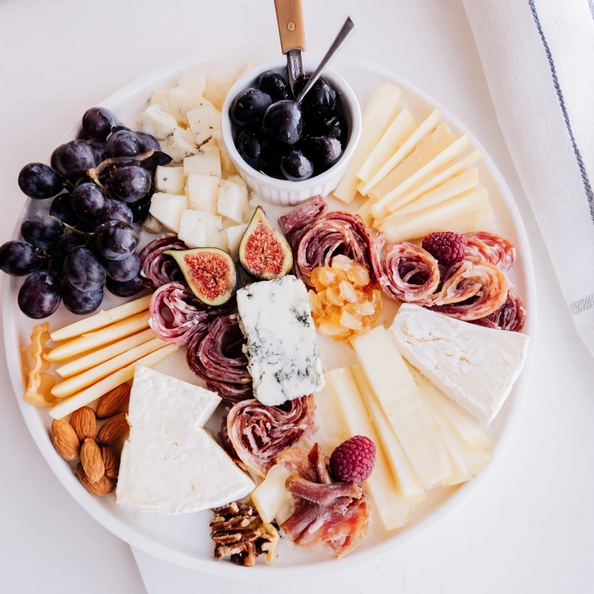 This Lace & Pearls Elegant Board displays a beautiful array of cheeses, meats, and colorful fruits.