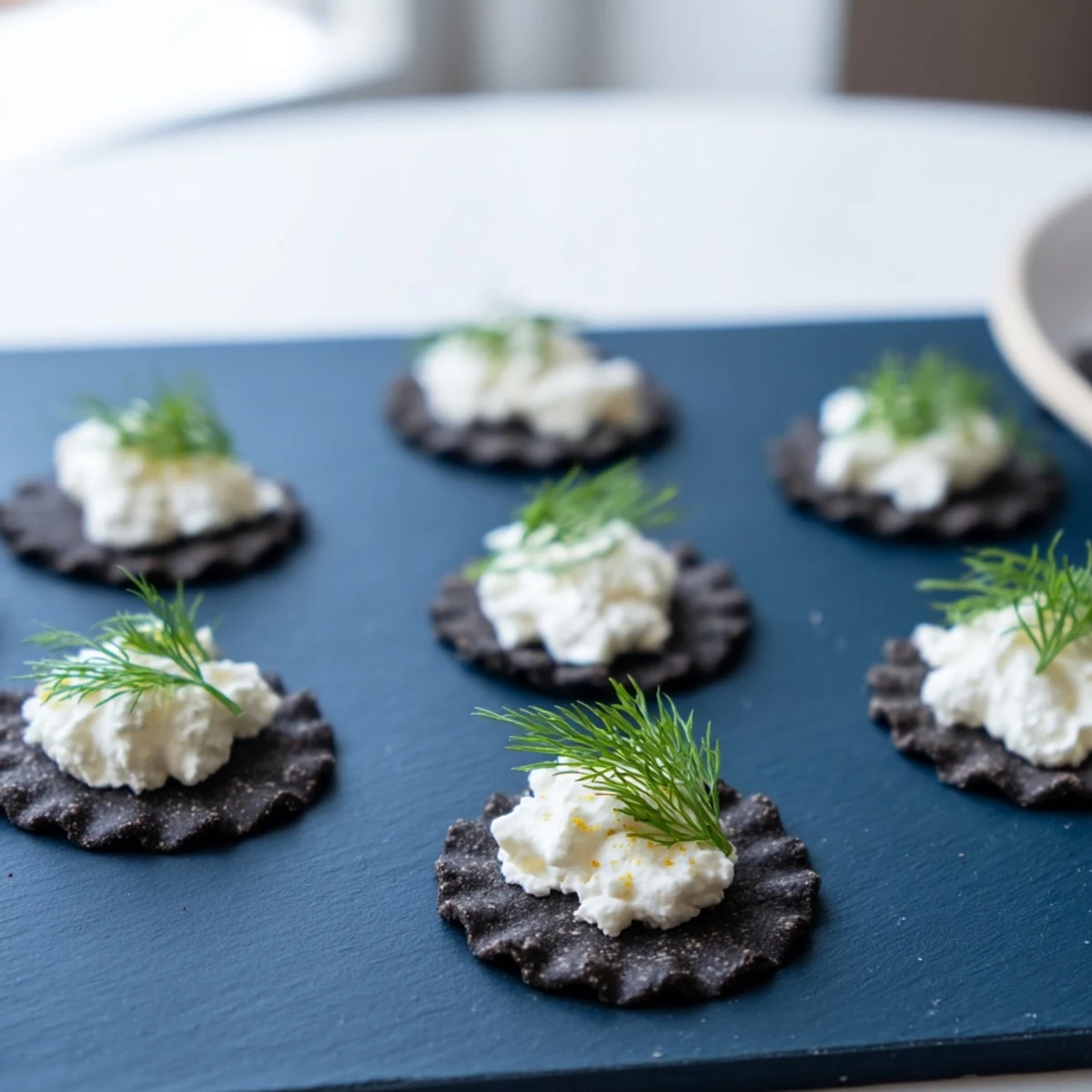 The Stormy Sea appetizer features wavy black crackers topped with creamy goat cheese “whitecaps” on a blue slate.