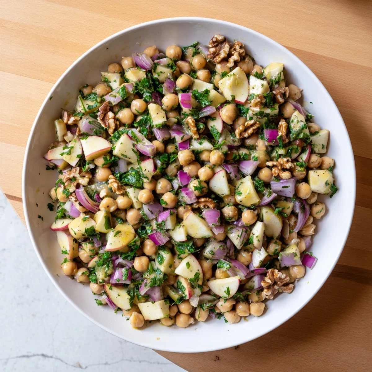 This Fall Harvest Apple and Chickpea Salad displays a medley of textures and flavors, ready to eat alongside a meal.