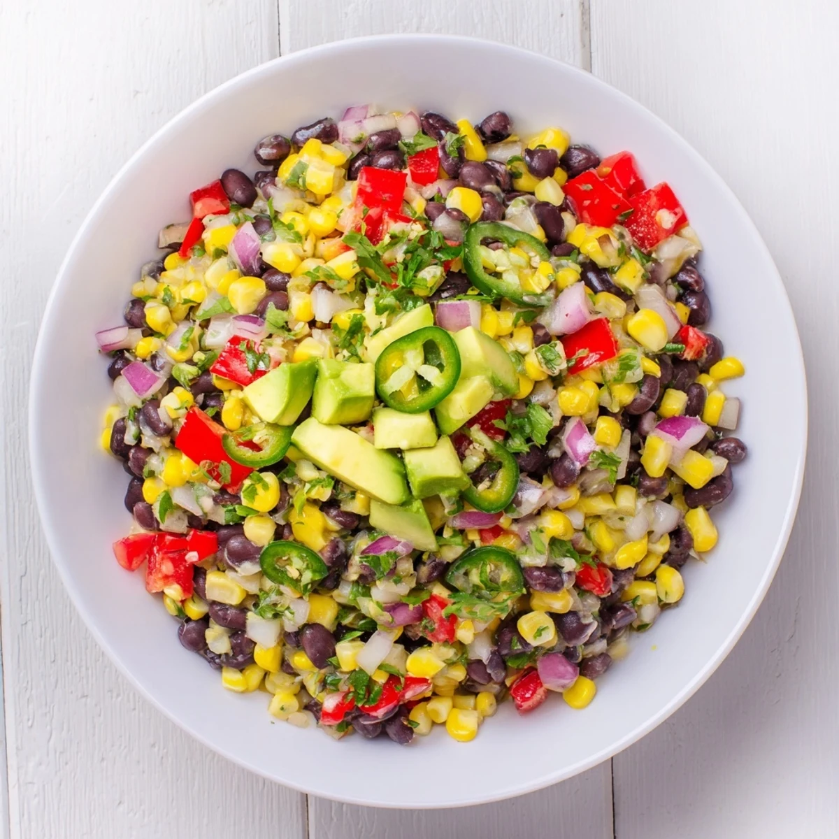 A close-up shot of Southwestern Black Bean and Corn Salad, showing juicy tomatoes and crisp veggies.