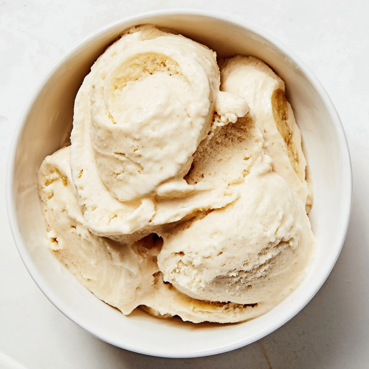 Homemade 2-Ingredient Banana Ice Cream served with fresh berries, a delightful, healthy dessert option.