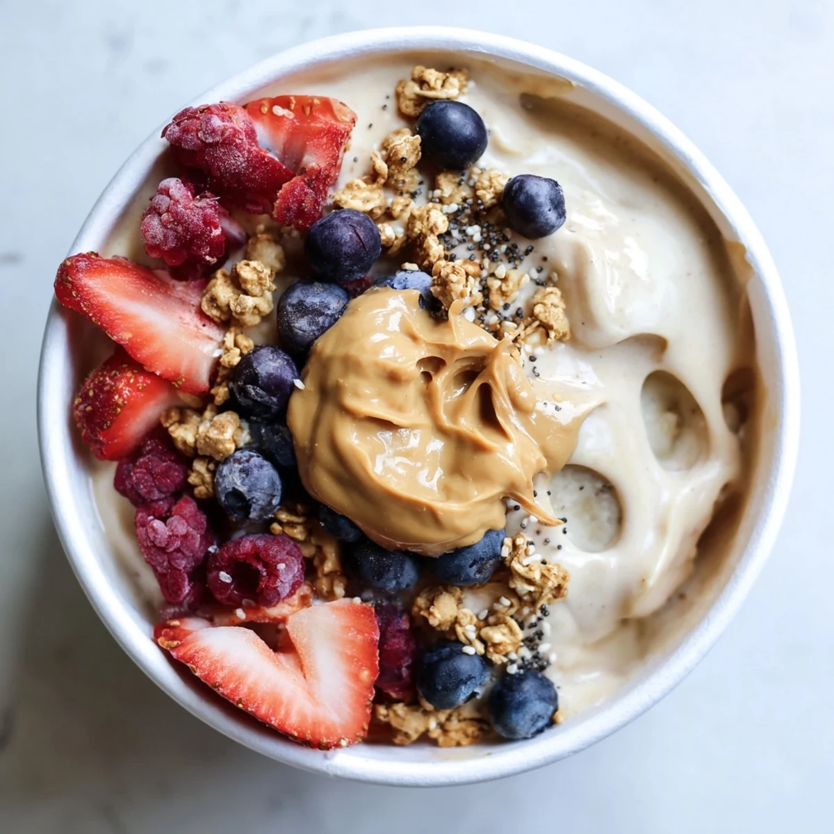 Homemade Protein Ice Cream Bowls, a blended treat, featuring a swirl of peanut butter and crunchy granola.