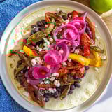 A beautifully arranged Desert Bloom Cactus Taco Board, ready for gathering, loaded with various toppings.
