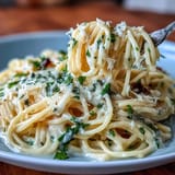 Bright and zesty lemon butter pasta dish with golden garlic butter sauce, garnished with Parmesan and parsley.
