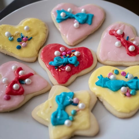 Pretty Bows Heart & Star Cookies look delicious, frosted with vibrant colors and adorned bows, ready to serve.