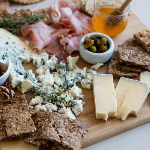 A delicious Winter Mountain Cheese Platter with assorted cheeses, charcuterie, and fresh fruit.
