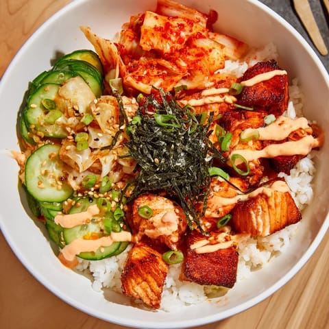 Delicious crispy salmon rice bowl garnished with garlic, avocado, and tangy flavors.  