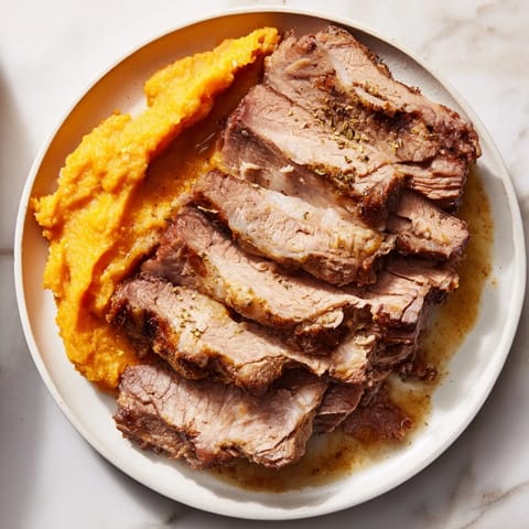 Slices of savory Classic Brisket & Mashed Sweet Potatoes are beautifully presented, a comforting family meal.
