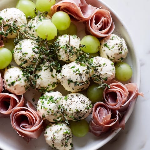 Round festive Mistletoe Kissing Ball loaded with green grapes and cheese, ready for serving.