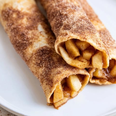 Melted butter glistens on the baked Apple Pie Roll-Ups, showing spiced apple filling inside.