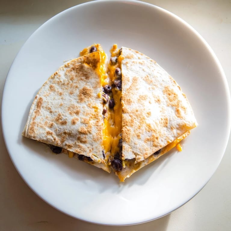 Crispy flour tortillas filled with beans and cheese: These Bean & Cheese Quesadillas are quick comfort food.