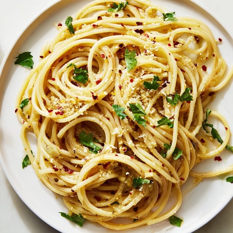Close-up of freshly made Aglio e Olio express pasta, garnished with parsley and a sprinkle of Parmesan.
