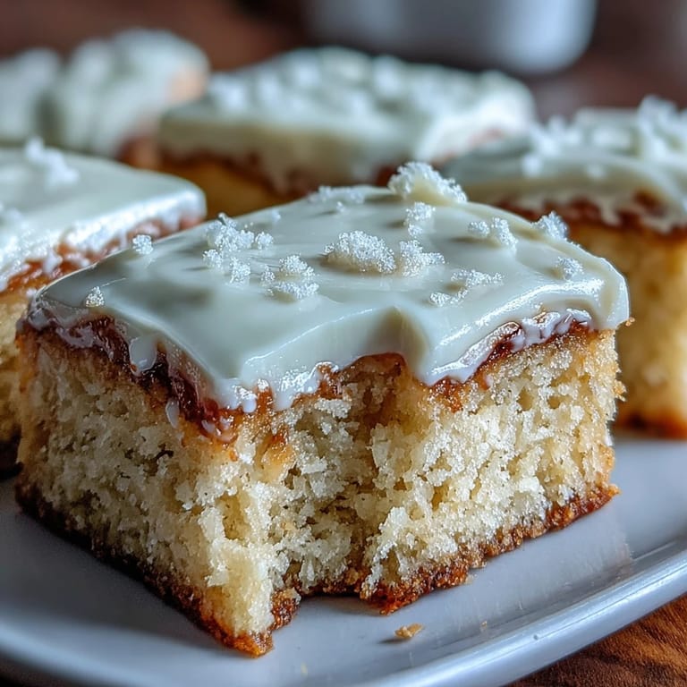 Gluten-free Almond Flour Sugar Cookie Bars are arranged on a white plate, ready to serve with a glass of milk.